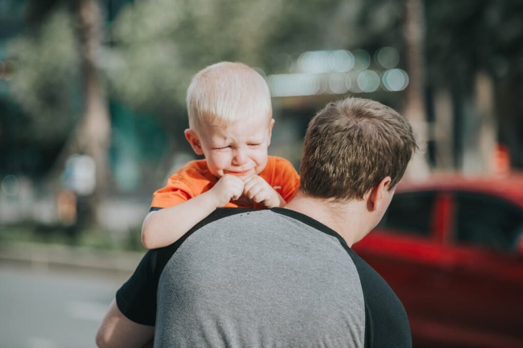 crying child being carried away by his father