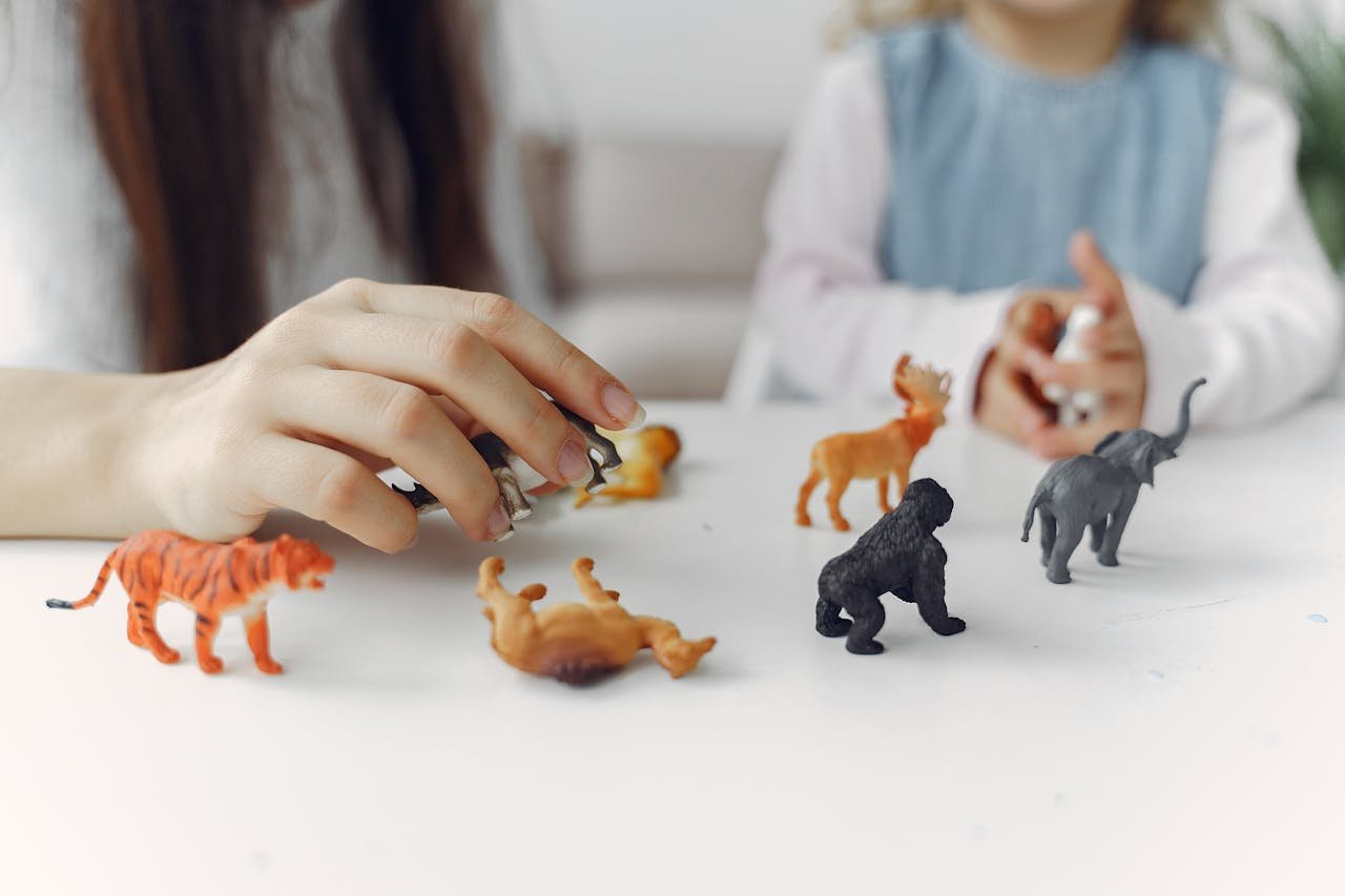adult and child playing with plastic figurines